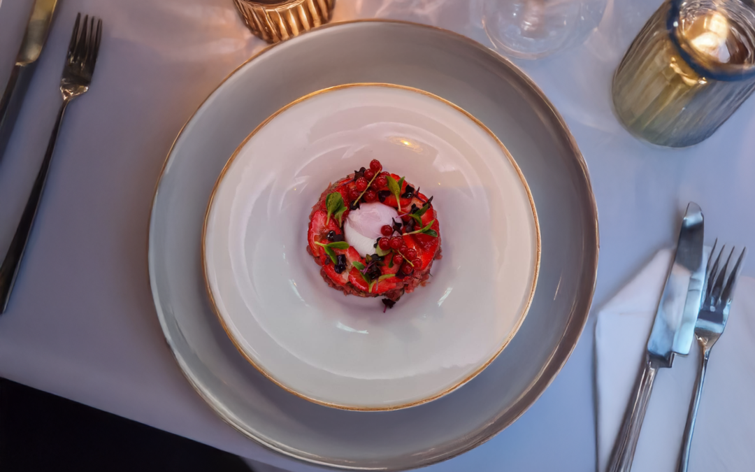 Tartar di Vitellino mit roten Früchten und pochiertem Ei